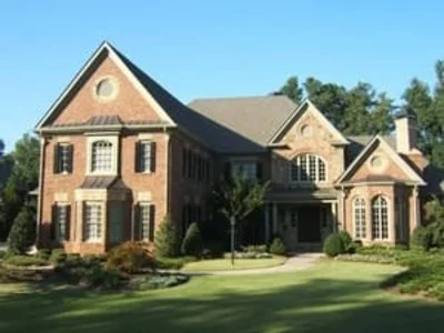 Two-story brick colonial home with newly installed windows and manicured landscaping