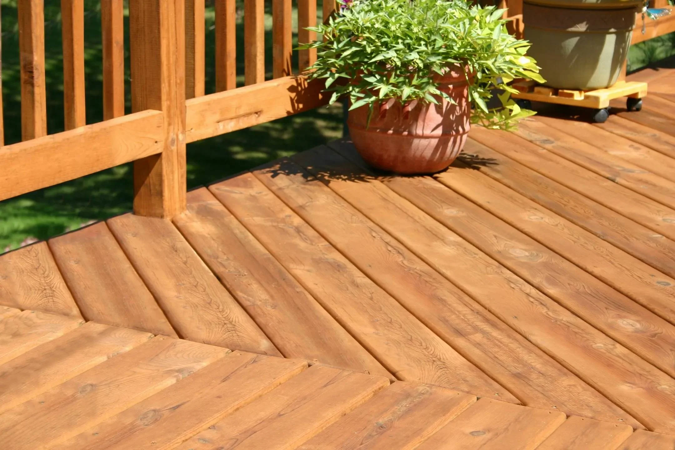 Newly constructed wooden deck with diagonal decking pattern and wooden railings in natural finish